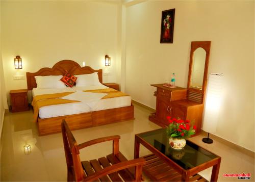 una habitación de hotel con una cama y una mesa con una mesa sidx sidx en Holiday Villa, en Thekkady