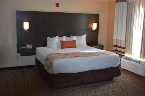 a hotel room with a large bed with an orange pillow at Hawthorn Suites Las Vegas in Las Vegas