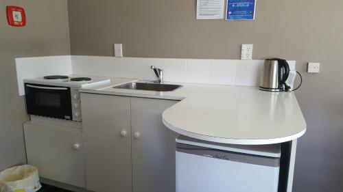 a small kitchen with a sink and a stove at High Country Lodge, Motels & Backpackers in Twizel