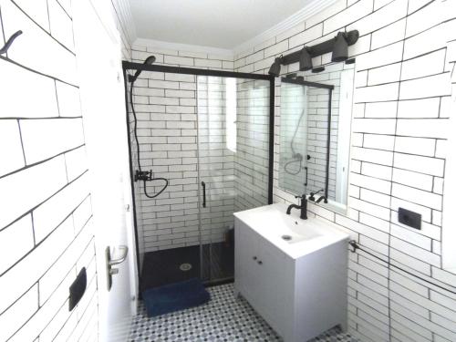 Baño blanco con lavabo y espejo en Luxury Cuchillería Vitoria, en Vitoria-Gasteiz