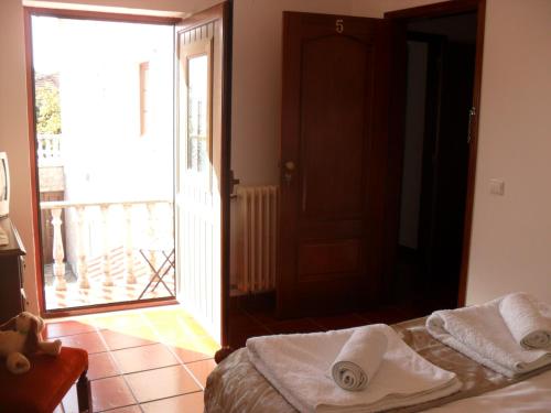 Schlafzimmer mit einem Bett und einer Tür zu einem Balkon in der Unterkunft Casa Vale Florido in Alvorge