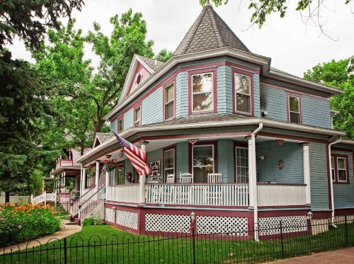 a blue house with an american flag in front of it at Holden House 1902 Bed & Breakfast Inn in Colorado Springs