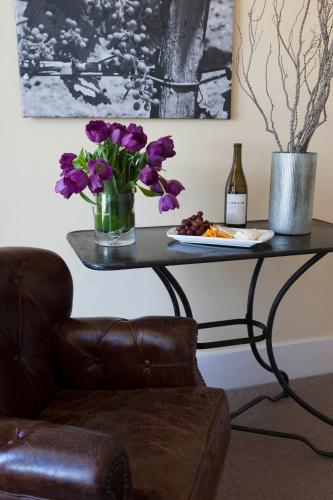 a table with a vase of flowers and a plate of food at Inn at Sonoma, A Four Sisters Inn in Sonoma