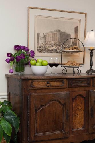 a table with two glasses of wine and a bowl of fruit at Inn at Sonoma, A Four Sisters Inn in Sonoma