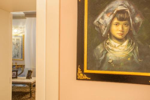 a painting of a woman is hanging on a wall at Martins Residence de Luxe in Ravenna