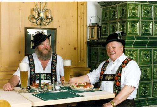 Twee mannen zitten aan een tafel met bier. bij Gasthaus am Zierwald in Grainau