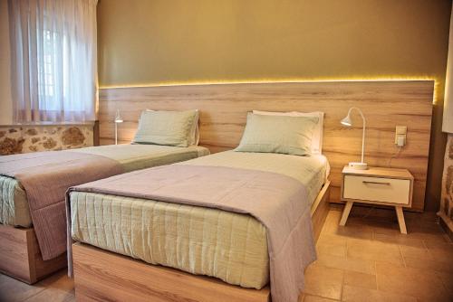 een slaapkamer met 2 bedden en een lamp op een nachtkastje bij Villa Kapela in Sívas