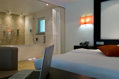 Un pat sau paturi într-o cameră la Cocoon Hotel La Rive