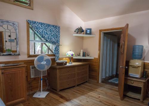un salon avec un ventilateur et une fenêtre dans l'établissement Blue Island Divers Casita Azul, à Sandy Bay