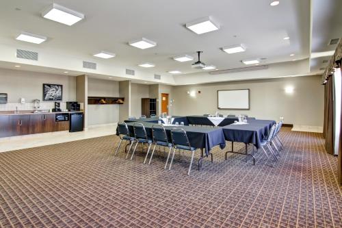 a conference room with tables and chairs and a screen at Canalta Hotel Esterhazy in Esterhazy