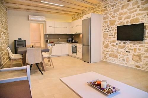 a kitchen and living room with a table and a tv at Villa Kapela in Sívas