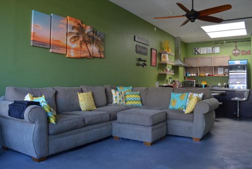 a living room with a gray couch and a green wall at California Dreams Hostel - Pacific Beach in San Diego
