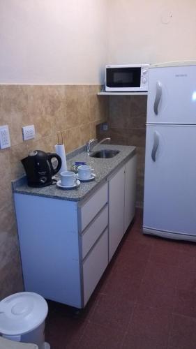 a small kitchen with a sink and a refrigerator at Apart Office in San Miguel de Tucumán