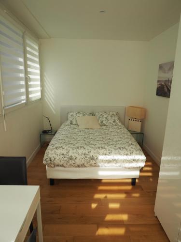 a bedroom with a bed and a wooden floor at Appartement place Golbéry in Strasbourg
