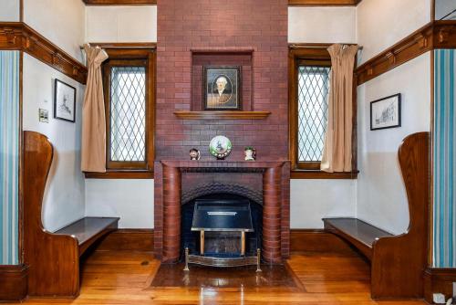 a living room with a fireplace and windows at Noble Waterfront Suites in Brockville