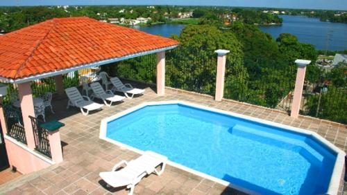 a swimming pool with chairs and a gazebo at Hotel & Suites Real del Lago in Villahermosa