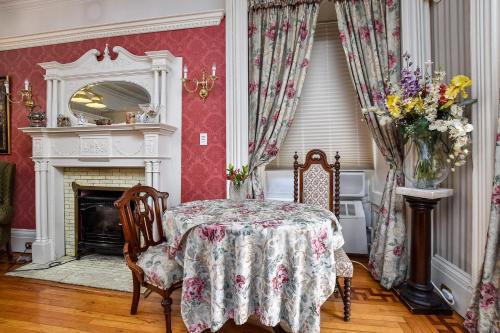 a dining room with a table and a fireplace at Noble Waterfront Suites in Brockville