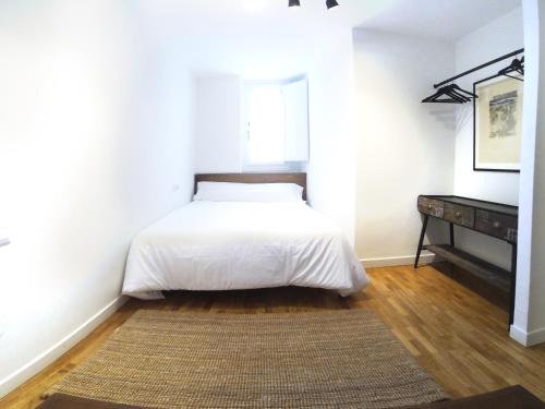 a bedroom with a bed and a dresser in it at Luxury Cuchillería Vitoria in Vitoria-Gasteiz