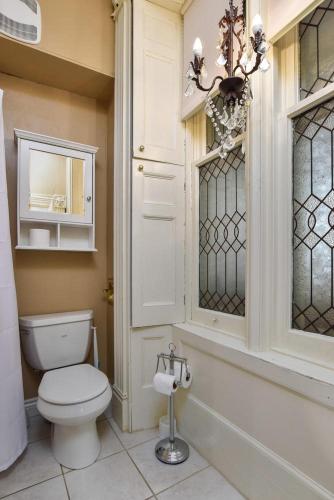 a bathroom with a white toilet and a window at Noble Waterfront Suites in Brockville