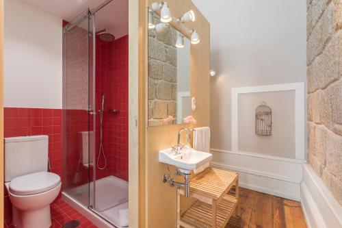 a bathroom with a toilet and a sink and a shower at Ribeira Historic Apartments in Porto