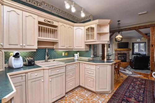 a kitchen with a sink, stove, cabinets and a counter top at The Noble Suites in Brockville