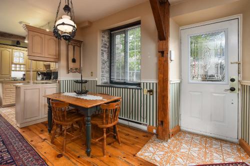 a kitchen with a table and chairs and a door at Noble Waterfront Suites in Brockville