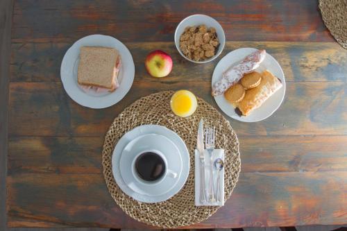 a table topped with plates of food and a cup of coffee at Aminta Home in Las Palmas de Gran Canaria