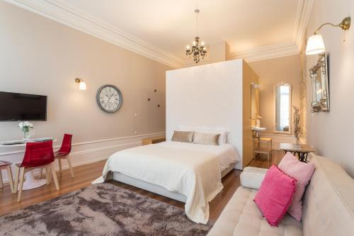 a bedroom with a bed and a table and a couch at Ribeira Historic Apartments in Porto