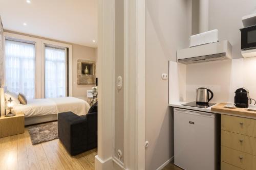 a room with a bedroom with a bed and a kitchen at Ribeira Historic Apartments in Porto
