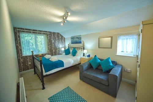 - une chambre avec un lit, un canapé et une chaise dans l'établissement Forrester House, à Canterbury