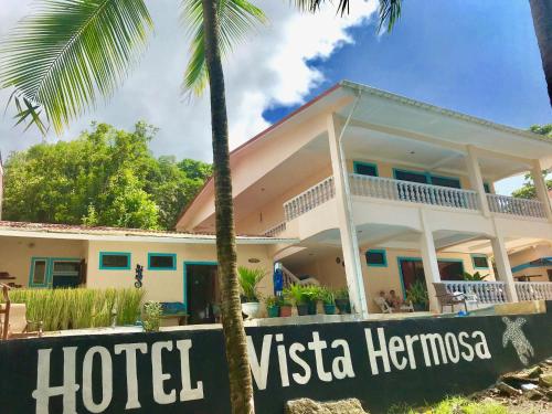 a house with a hotel sign in front of it at Hotel Beachfront Vista Hermosa in Jacó