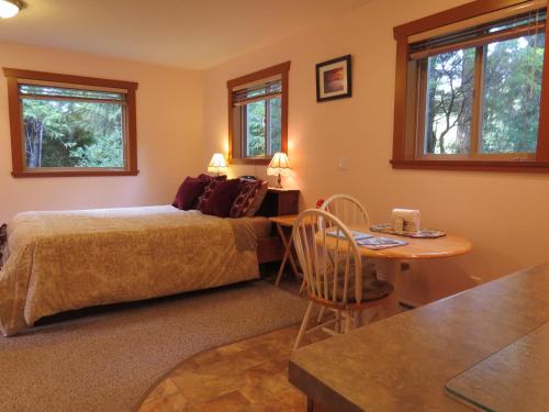 1 dormitorio con 1 cama y 1 mesa en Summerhill Guest House, en Tofino