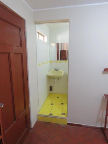 a bathroom with a sink and a yellow tile floor at Casa particular de Jorge Edinson in Lima