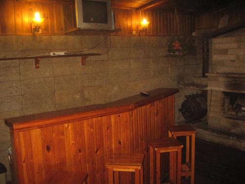 un bar con taburetes y TV en la pared en Tammekännu Holiday House en Mammaste