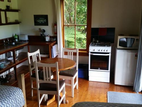 a kitchen with a table and chairs and a stove at The Innlet, Country Apartments and Cottages in Collingwood
