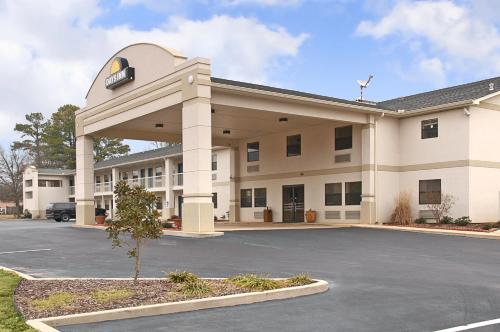 a large white building with a parking lot at Days Inn by Wyndham Fordyce in Fordyce