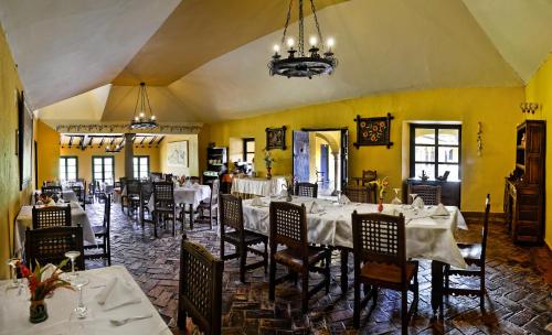 a restaurant with white tables and chairs and a chandelier at Hotel Hacienda El Salitre in Paipa