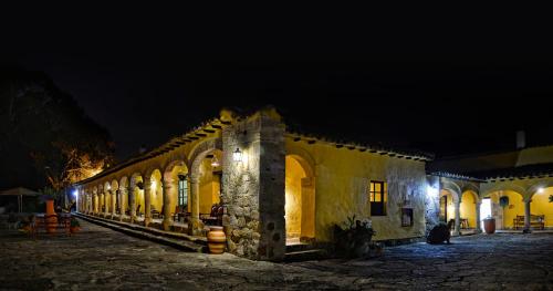 an old building at night with its lights on at Hotel Hacienda El Salitre in Paipa