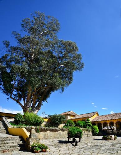 a tree in a stone courtyard with a tree at Hotel Hacienda El Salitre in Paipa