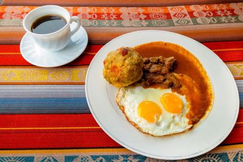 a plate of food with eggs and a cup of coffee at El Aliso - Pujilí in Pujilí