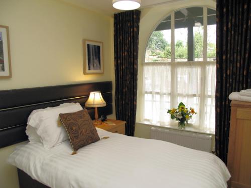 a bedroom with a white bed and a window at Croft Mill in Hebden Bridge