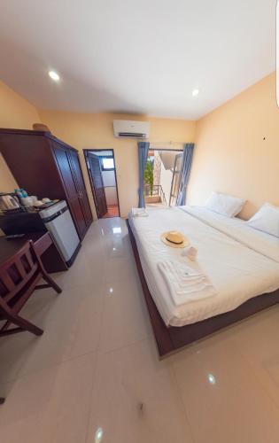 a bedroom with a large white bed with a table at Morakot Lanta Resort in Ko Lanta