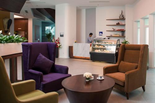 a lobby with two chairs and a table and a counter at Wyne Hotel in Yangon