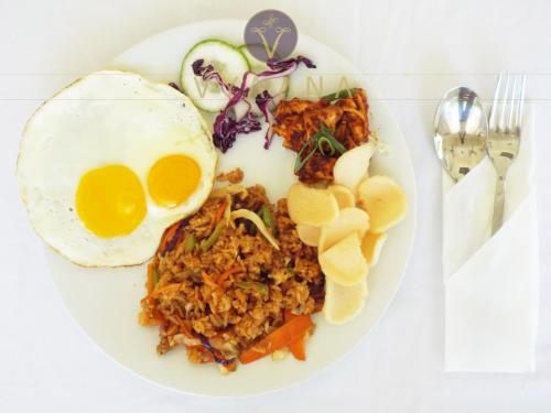 a plate of food with an egg and rice at Vyaana Resort Gili Air in Gili Air