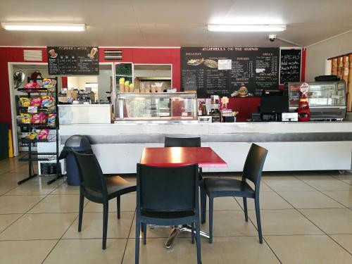 a restaurant with a table and chairs in front of a counter at Augathella Motel & Caravan Park in Augathella