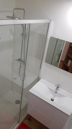 une salle de bain blanche avec un lavabo et un miroir dans l'établissement Les Carroz d'Araches, aux Carroz d'Arâches