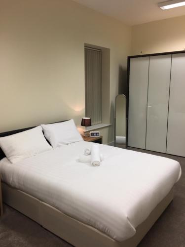 ダブリンにあるノース シティ ロッジ セルフ ケータリングのベッドルーム1室(大きな白いベッド1台、タオル付)