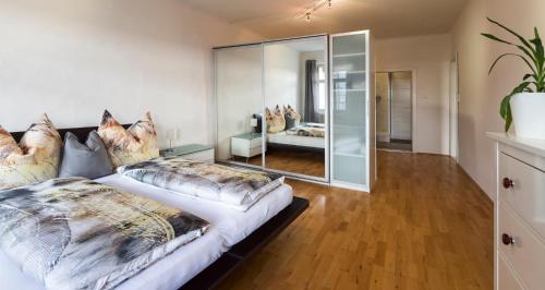ザルツブルクにあるNext2Mozart-Apartmentのベッドルーム1室(ベッド2台、大きな鏡付)