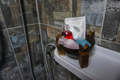 a bathroom shelf with a bottle and tooth brushes at Cocco House in Ao Nang Beach
