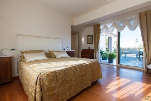 a bedroom with a bed and a large sliding glass door at Verdeluna ApartHotel in Marina di Pietrasanta